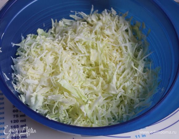Нашинкуйте капусту, лук нарежьте полукольцами и добавьте к капусте.