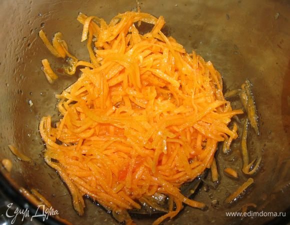 Готовые креветки выложил шумовкой на салфетку, а оставшееся в сковороде горячее масло вылил в морковь и перемешал.