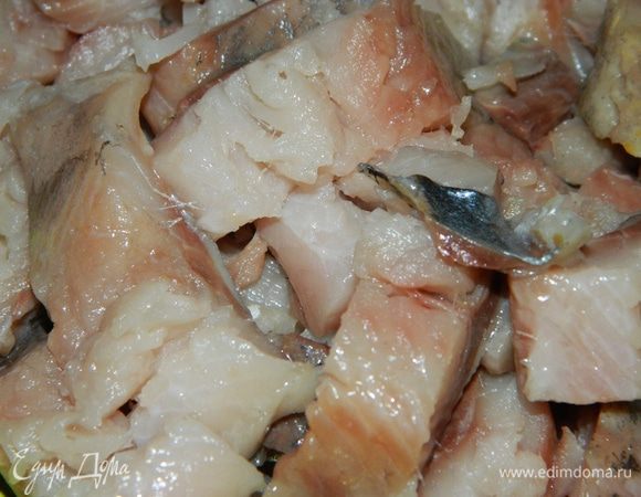 На третьи сутки достаньте рыбу и очистите ее: отрежьте голову, хвост, плавники, уберите кожу и кости. Филе сельди нарежьте небольшими кусочками.