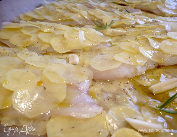 Сверху на рыбку выкладываем снова картофель, солим, перчим, сбрызгиваем соком апельсина, посыпаем цедрой апельсина, выкладываем розмарин и разрезанный вдоль на несколько долек чеснок. Сбрызгиваем оливковым маслом и ставим в духовку примерно на полчаса. 