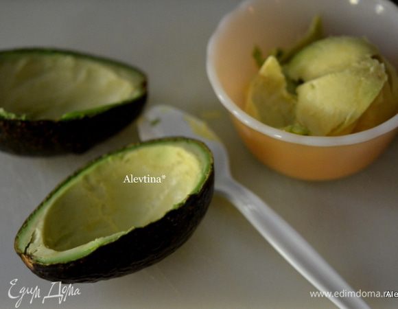 Осторожно разрежем авокадо на 2 части.  Снимем мякоть в емкость так, чтоб по стеночкам осталось.