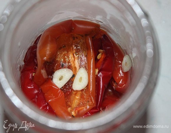 После, вяленые перцы сложить в банку, прослоить пластинками чеснока и залить оливковым маслом. Хранить в холодильнике.