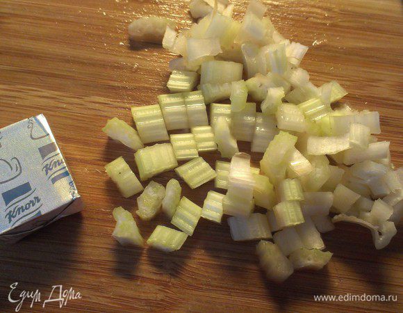 Добавьте мелко-порезанный сельдерей и куриный кубик к овощам.