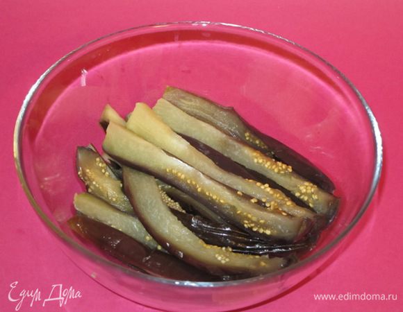 Остывшие баклажаны разрезать пополам, а затем длинными полосками.