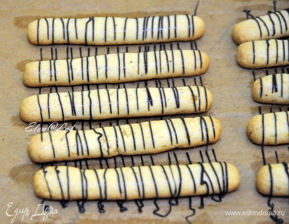 Теперь украшгаем остывшее печенье. для этого надо растопить отдельно темный и белый шоколад. И с помощью, корнетика или щприца украсить наше печенье шоколадными нитями.