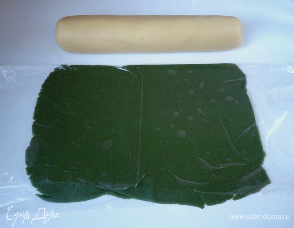 Светлую часть теста скатать цилиндром. А зеленую часть теста раскатать в тонкий плоский квадрат между двумя слоями пленки. Размер квадрата должен соответствовать  длине и диаметру светлого теста.
