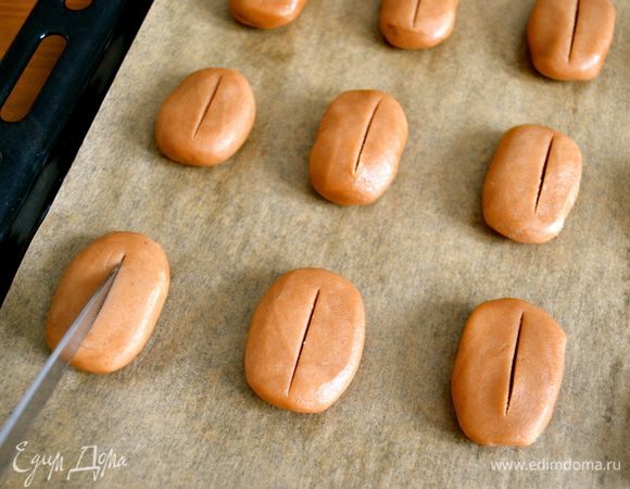 Полученный таким образом печенюшки выкладываем на противень, застеленный пекарской бумагой. Лезвием ножа делаем неглубокие надрезы.  