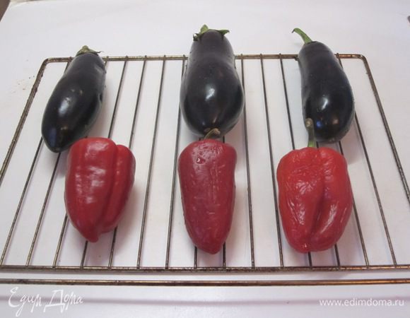 Баклажаны и перцы вымыть, выложить на решетку. Запекать 30-40 минут. Изредка надо посматривать и переворачивать. Как только кожица натянется, надо вынимать.