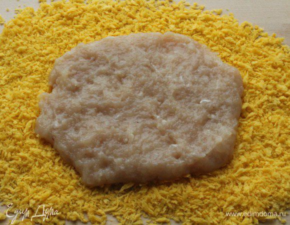 На разделочную доску насыпать хлебные крошки или панировку. Из фарша сделать небольшую лепешку.