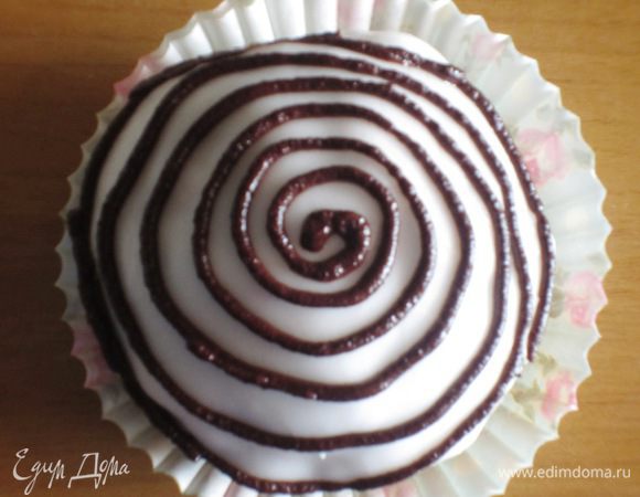 Наполнить кондитерский мешок шоколадным кремом и нанести на глазурь крем в виде спирали, начиная от центра. 