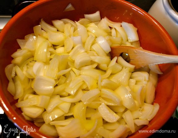 Тем временем в глубокой сковороде начинаем обжаривать в масле лук, до мягкости. 