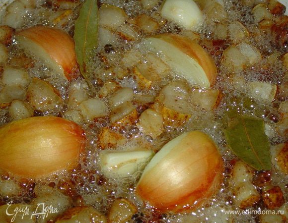 Одну луковице разрезаем на сегменты, не очищая, и кладем ее в сковороду к салу, так же добавляем перец горошек, лавровый лист, очищенный чеснок и обжариваем все вместе пару минут.