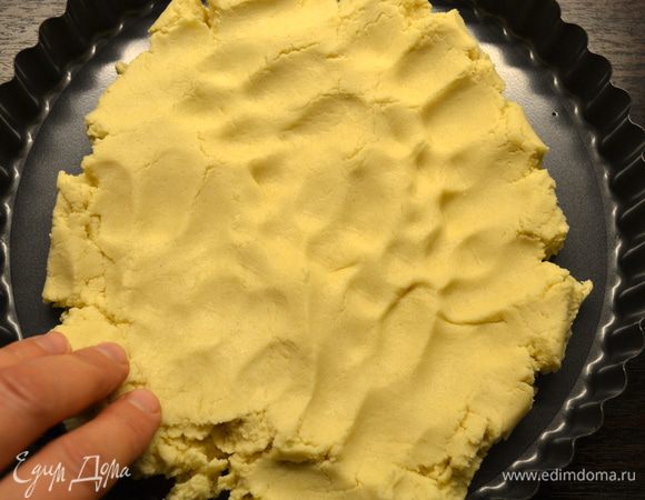 Утрамбовать тесто в дно разъемной формы диаметром 23 см.