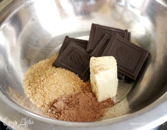 Шоколадный крем начинаем готовить, когда полностью охладится кофейный. Для этого в жаропрочную миску уложить шоколад, какао, сахар и сливочное масло. Установить миску на водяную баню и прогреть до полного растворения шоколада. Хорошо размешать.