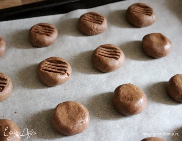 Выложить шарики теста на застеленный пергаментом противень. Тыльную сторону зубчиков вилки чуть-чуть смазать растительным маслом, затем опустить в отложенное какао и придавить зубцами печенье. Выпекать 15-20 минут при 180*С. Готовое печенье остудить.