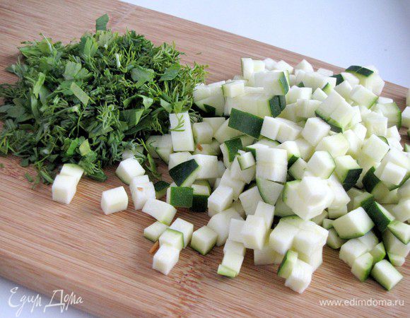Цукини нарежьте мелким кубиком, зелень измельчите.