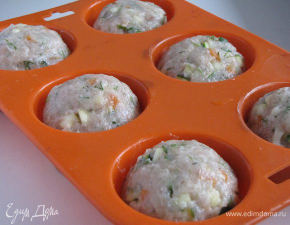 Руками, смоченными в холодной воде, сформируйте из фарша шарики и разложите их по формам для маффинов. Если нет формочек для маффинов, то можно запечь на противне, застеленным пекарской бумагой.