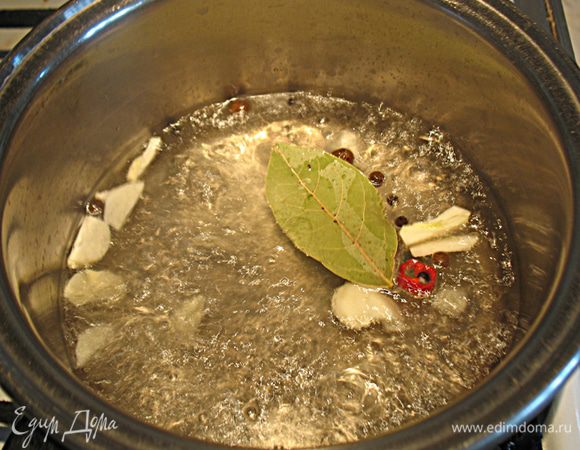 В кастрюльку влить соду, уксус и закипятить. К кипящую воду с уксусом  добавить соль, порезанный пластинками чеснок, другие специи. 