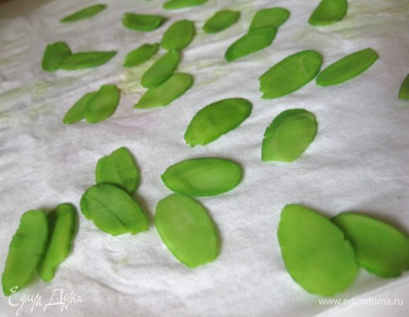 Я еще и украшала печенье листиками: в небольшую мисочку налить 3-4 ст.ложки воды, добавить зеленый краситель на кончике ножа, перемешать. В разведенный краситель выложить миндальные лепестки и подержать минут 15. Окрашенные лепестки аккуратно разложить на бумажной салфетке и дать им подсохнуть.
На отсаженные на противень печенья прикрепить сверху по два лепестка.