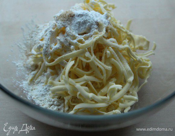 Насыпать в чашку муку, натереть сливочное масло, добавить соль и сахар, крахмал и разрыхлитель. Перетереть в крошку.