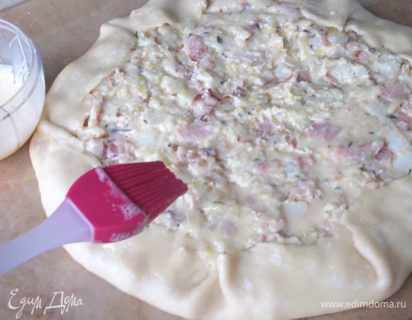 Свободный край набросить на начинку и смазать всю галету желтком.