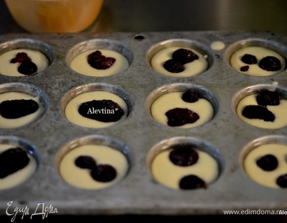 Форму для мини-маффинов смазать растительным маслом. Заполнить тестом каждую емкость на ⅔ часть. Выложить ягоды свежие или замороженные.
