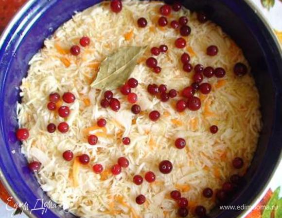 В кастрюлю выложите ⅓ часть капусты, утрамбуйте, сверху положите 1 лавровый лист и добавьте ⅓ клюквы. Повторите также еще 2 слоя.