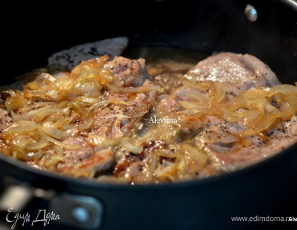 Затем вернуть свиные отбивные,выложив поверх них обжаренный лук и готовить все до полного приготовления свиных отбивных.