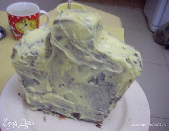 Обмазать заготовку масляным кремом - чтобы мастика не потекла от влажного бисквита (масло комнатной температуры смешать со сгущенным молоком и взбивать до однородной гладкой массы).