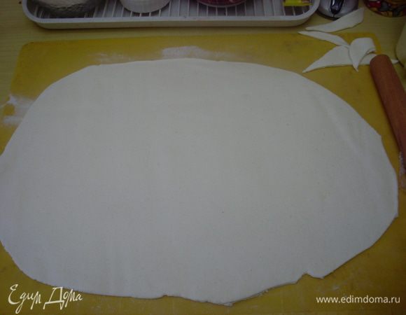 Раскатать мастику толщиной 3-4 мм в форме овала, приблизительно учесть размеры фигурки - в боков "рук" мастика тоже должна спускаться. У меня получился овал примерно 43 на 33 см. 
Мастика делается просто - зефир подогреть в микроволновке - чтобы он стал мягким, но еще не жидким. Выложить липкую массу на сахарную пудру и мешать, пока не получится пластичная мастика, не слишком липнущая к рукам. Сначала она может показаться жидковатой, но при охлаждении застынет как тесто на пельмени. Хранить в холодильнике в плотно закрытом пакете или контейнере.