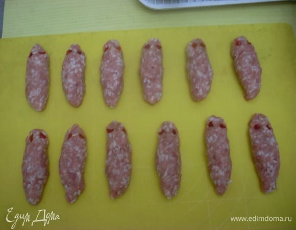 Слепить из фарша длинные колбаски, прикрепить будущим "мумиям" глаза. Заморозить получившиеся заготовки.