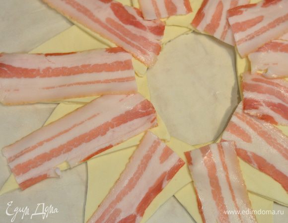 На тесто положить ломтики бекона.