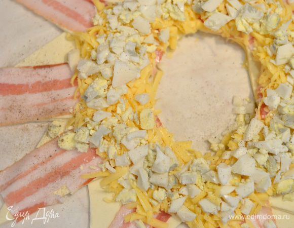 Затем поверх сыра выложить отварные и мелко порубленные яйца, засыпать остальным сыром.