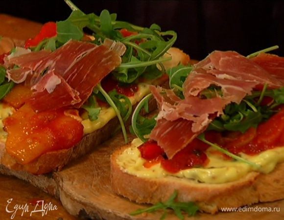 Хлеб смазать майонезом с каперсами, выложить на него обжаренные овощи, затем листья руколы, а сверху ветчину.