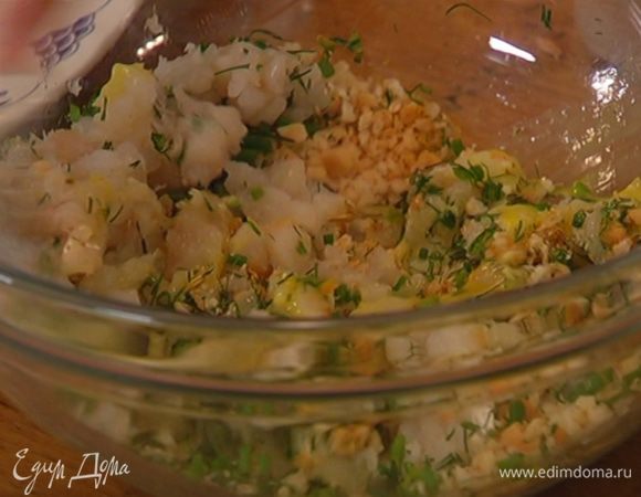 Выложить рыбу к сухарям с зеленью и специями, добавить половинку взбитого яйца и все перемешать.