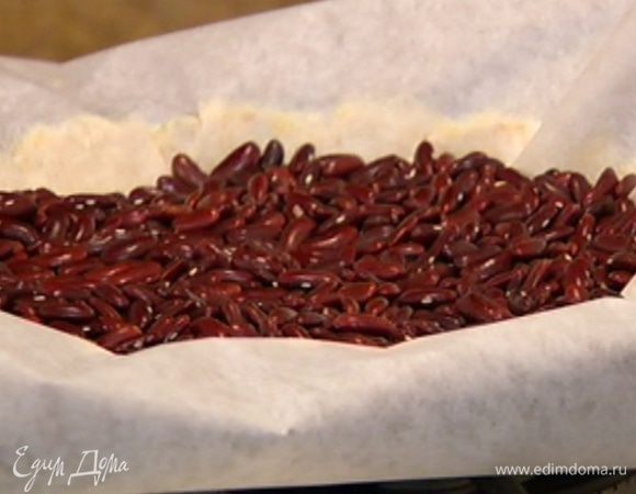 Тесто часто наколоть вилкой, накрыть бумагой для выпечки, насыпать на бумагу около килограмма фасоли (или любой крупы). Выпекать в разогретой духовке 15 минут, затем бумагу с крупой убрать.