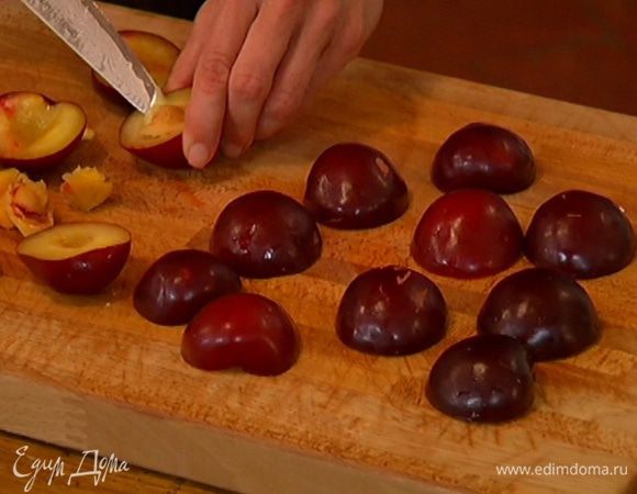 Сливы разрезать пополам и удалить косточки.