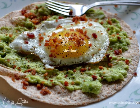 Выложить на поверхность питы мякоть авокадо с соком лайма ,сверху яйцо поджаренное и бекон. Посолить и поперчить и приятного аппетита.
