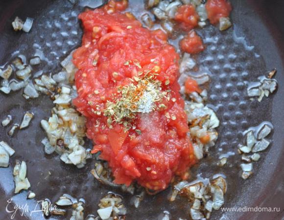 Помидоры натираем на терке и добавляем в лук. Приправляем орегано, перцем и сахаром. Тушим в течении 4 минут.