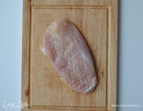Филе разрезаем поперек на 3 части, заворачиваем в пищевую пленку, отбиваем и солим.