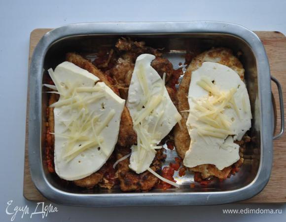 В глубокий противень выкладываем томатную массу, куриные отбивные, нарезанную тонкими пластинами брынзу и посыпаем пармезаном. Выпекаем в течении 15-20 минут.