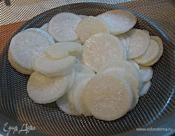 Хорошо посолите дайкон, переложите в дуршлаг и оставьте на час, чтобы стекла жидкость и ушла горечь.