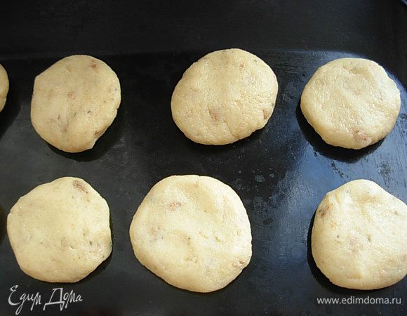 От теста отщипывать кусочки, размером с грецкий орех, катать шарик, а затем приплюснуть, придав форму круглой печеньки.
Выложить на не смазанный лист, либо на пергамент, на довольно большом расстоянии, печенье немного приподнимается.
