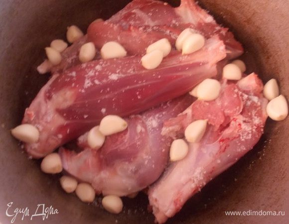 Затем выкладываем наши голяшки на морковь, солим, перчим, добавляем специи и чеснок.