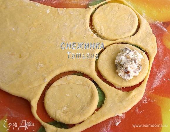 Теперь формируем вареники. Берём часть теста, раскатываем, постоянно подсыпая муку, не слишком тонко. Вырезаем стаканом круги. На половинку круга кладём начинку.