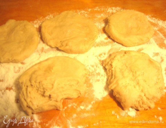 Отщипываем кусочек теста размером с яйцо и приминаем в лепёшечку на доске с мукой.