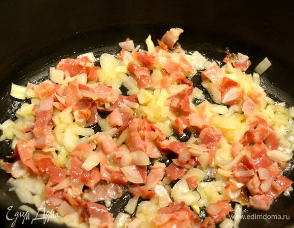 В глубокой кастрюле с тяжелым дном в разогретом сливочном масле обжарить нарезанный бекон и лук.  