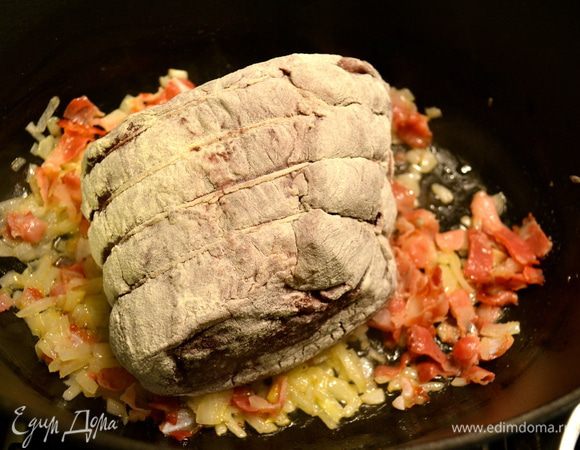 Мясо достать из маринада, обсушить бумажным полотенцем, обвалять в муке и положить обжариваться в кастрюлю с луком и беконом. 