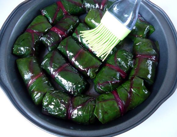 Форму смазать растительным маслом. Выложить на него голубцы. Верх голубцов тоже немного  смазать маслом. Поставить в разогретую духовку на 200 гр. примерно на 15 минут.
 Пока готовятся голубцы приготовить соус. Чеснок растолочь в ступке. Зелень измельчить. Сметану или йогурт смешать с зеленью, чесноком и приправить специями. 
