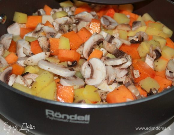 Грибы нарежьте небольшими кусочками. Чеснок очистите, раздавите плоской стороной ножа. В сотейнике разогрейте растительное масло. Добавьте картофель, тыкву, грибы и чеснок. Накройте крышкой и тушите на среднем огне около 10 минут, периодически помешивая. 
